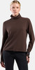 Frau in braunem Rollkragenpullover und langer schwarzer Hose.
