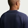 Rückansicht eines Mannes in einem dunkelblauen T-Shirt mit kurzen Ärmeln.