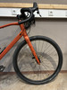Orange Gravelbike mit schwarzem Lenker und Vorderrad.