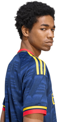 Mann in blauem Trikot mit gelben Streifen und rotem Kragen, der über die Schulter blickt. Mann in blauem Trikot mit gelben Streifen und rotem Kragen, der über die Schulter blickt.