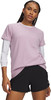 Frau in einem rosa Langarmshirt und schwarzen Shorts.