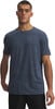 Mann in einem dunkelblauen kurzärmeligen T-Shirt und schwarzer Hose.