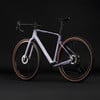 Lila Gravelbike mit buntem Muster auf dem Rahmen und braunen Laufrädern.