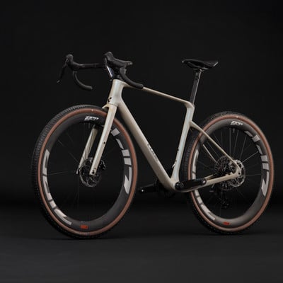 Ein beiger Gravelbike mit braunen Reifen und schwarzen Zipp-Felgen. Ein beiger Gravelbike mit braunen Reifen und schwarzen Zipp-Felgen.