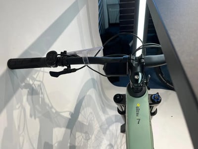 Detail des E-Bike-Lenkers mit Display und Bremshebel auf weißem Hintergrund. Detail des E-Bike-Lenkers mit Display und Bremshebel auf weißem Hintergrund.