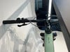 Detail des E-Bike-Lenkers mit Display und Bremshebel auf weißem Hintergrund.