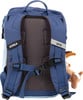 Die Rückseite eines blauen Rucksacks mit einem Reflektorstreifen und einem Plüschtier.