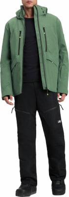 Ein Mann in einer grünen Kapuzenjacke und schwarzer Hose steht.
