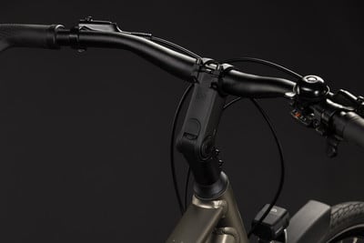 Detailansicht des Lenkers eines E-Bikes mit verstellbarem Vorbau und Klingel.