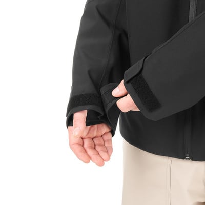 Ein Mann schließt den Klettverschluss am Ärmel einer Jacke.