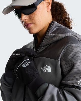 Frau in einer Winterjacke und Handschuhen von The North Face mit Brille. Frau in einer Winterjacke und Handschuhen von The North Face mit Brille.
