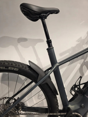 Das Heck eines dunkelgrauen E-Bikes mit Schutzblech und Sattel. Das Heck eines dunkelgrauen E-Bikes mit Schutzblech und Sattel.