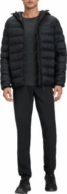 Ein Mann in einer schwarzen Daunenjacke mit Kapuze, schwarzer Hose und Schuhen.