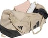 Beige Adidas Sporttasche mit schwarzen Streifen und Zubehör.