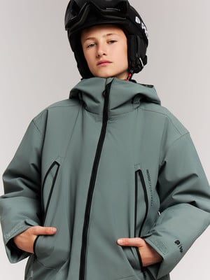 Junge in Skiausrüstung mit Helm und Jacke mit schwarzem Reißverschluss. Junge in Skiausrüstung mit Helm und Jacke mit schwarzem Reißverschluss.
