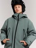 Junge in Skiausrüstung mit Helm und Jacke mit schwarzem Reißverschluss.