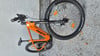 Ein orangefarbenes KTM-Mountainbike mit schwarzen Schwalbe-Reifen steht auf Schotter.