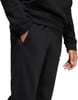 Detail einer schwarzen Sporthose mit einer Tasche und einer Hand darin.