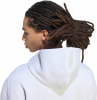 Rückansicht einer Person mit Dreadlocks, die einen hellen Kapuzenpullover trägt.