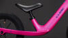Ein pinkes Kinderfahrrad mit schwarzem Sattel und blauem Cube-Logo.