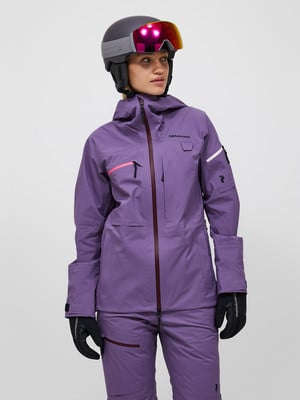 Frau in lila Skijacke und Hose mit Helm und Brille. Frau in lila Skijacke und Hose mit Helm und Brille.