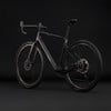 Elegantes schwarzes Carbon-Gravelbike mit breiten Reifen.