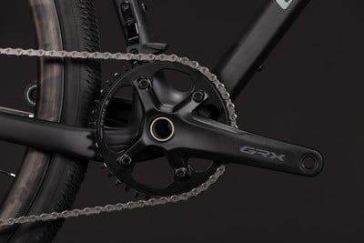 Detail des GRX-Kettenblatts an einem schwarzen Fahrrad mit Kette. Detail des GRX-Kettenblatts an einem schwarzen Fahrrad mit Kette.