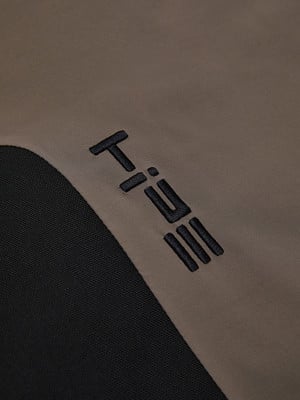 Das Logo T:IIE ist auf braunem Stoff mit schwarzem Einsatz aufgestickt.