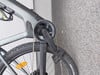 Teil eines E-Bikes mit Kurbel, Kette und Pedal an der Wand.