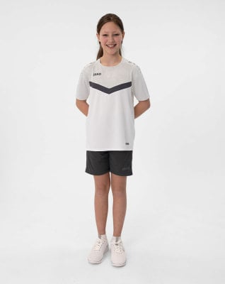 Mädchen in weißem T-Shirt mit dunklem Streifen und schwarzer Hose auf weißem Grund.