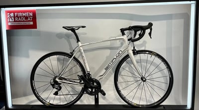 Ein weißes Simplon Rennrad mit Schriftzug auf dem Rahmen im Geschäft. Ein weißes Simplon Rennrad mit Schriftzug auf dem Rahmen im Geschäft.