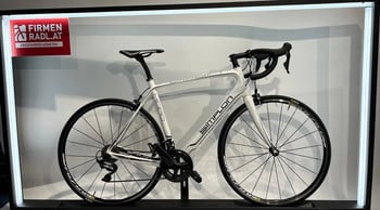 Ein weißes Simplon Rennrad mit Schriftzug auf dem Rahmen im Geschäft.