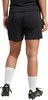 Rückansicht einer Person in schwarzer Hose, weißen Socken und Fußballschuhen.