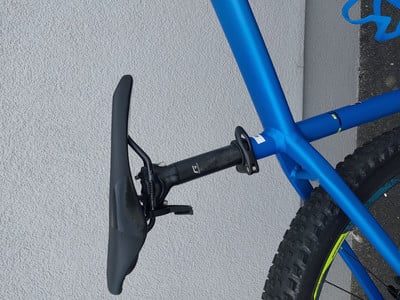 Ein blaues Fahrrad mit schwarzem Sattel und einer am Rahmen befestigten Sattelstütze. Ein blaues Fahrrad mit schwarzem Sattel und einer am Rahmen befestigten Sattelstütze.