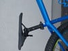 Ein blaues Fahrrad mit schwarzem Sattel und einer am Rahmen befestigten Sattelstütze.