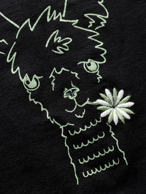 Gestickte Zeichnung einer Lama mit Blume auf schwarzem Hintergrund. Gestickte Zeichnung einer Lama mit Blume auf schwarzem Hintergrund.