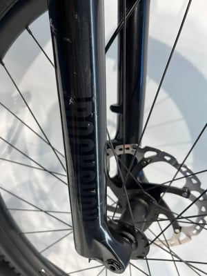 Detail einer Fahrrad-Vorderradgabel mit Scheibenbremse und Schriftzug. Detail einer Fahrrad-Vorderradgabel mit Scheibenbremse und Schriftzug.