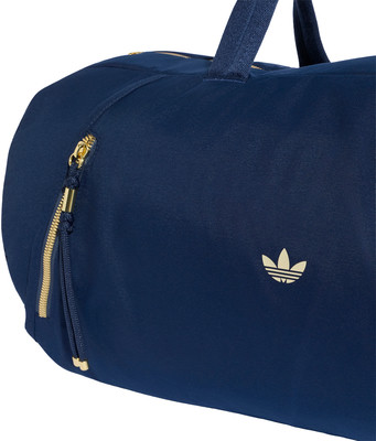 Dunkelblaue Adidas-Tasche mit goldenem Logo und Reißverschlüssen. Dunkelblaue Adidas-Tasche mit goldenem Logo und Reißverschlüssen.