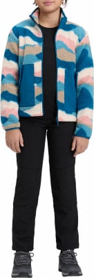 Mädchen in bunter Fleecejacke und schwarzer Hose steht. Mädchen in bunter Fleecejacke und schwarzer Hose steht.