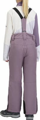 Mädchen in Latzhose und einer Jacke mit Farbblöcken. Mädchen in Latzhose und einer Jacke mit Farbblöcken.