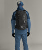 Ein Mann in Skikleidung mit einem Rucksack auf dem Rücken.
