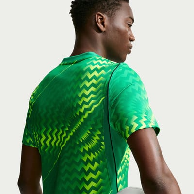 Mann in einem grünen T-Shirt mit geometrischem Muster, von hinten gesehen. Mann in einem grünen T-Shirt mit geometrischem Muster, von hinten gesehen.