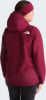 Frau in dunkelroter The North Face Jacke mit Kapuze und Stirnband.