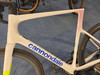 Ein weißes Cannondale Rennrad mit blauem Logo und rotem Muster.