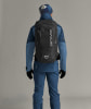 Mann in Skibekleidung mit Rucksack von hinten gesehen.