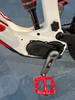 Detail eines weißen E-Bikes mit roten Akzenten und Dämpfer.