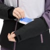 Eine Frau steckt eine Karte in die Jackentasche, Nahaufnahme der Hand.