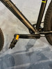 Detail eines schwarzen Fahrradrahmens mit Shimano-Pedal und teilweise sichtbarem Reifen.