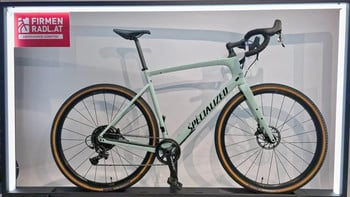 Ein hellgrünes Specialized Gravelbike mit braunen Reifen.