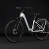 Ein silbernes E-Bike mit schwarzen Akzenten auf schwarzem Hintergrund.